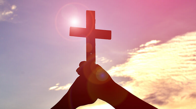 Faith-Christian-Cross-Hands-Sky-Sun-Glare_credit-Shutterstock