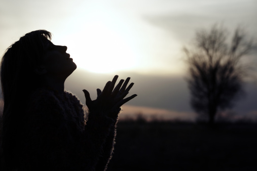 Praying woman in field