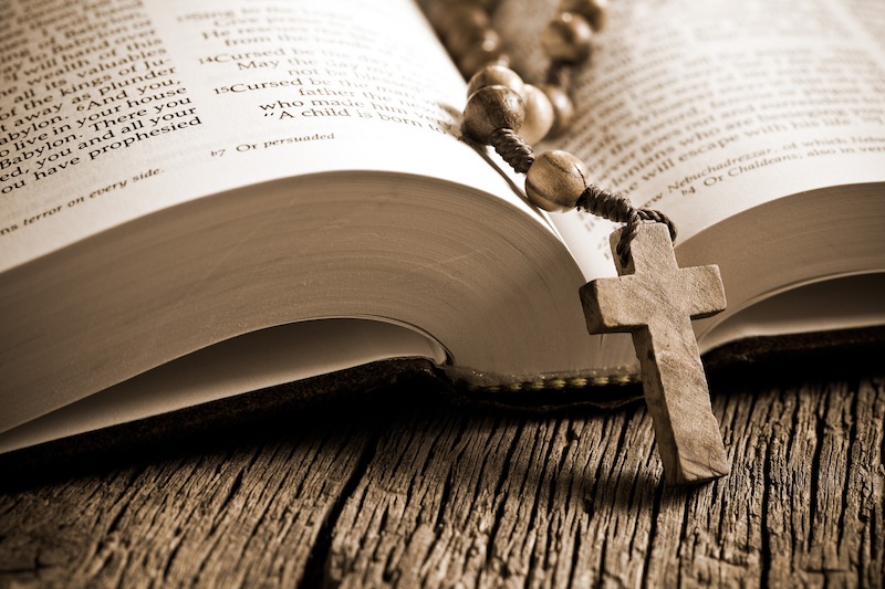 the wooden rosary on the open Bible