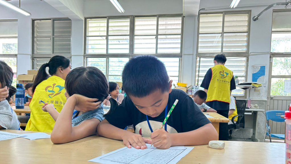 孩子很认真地写大哥哥大姊姊们指定的英文作业