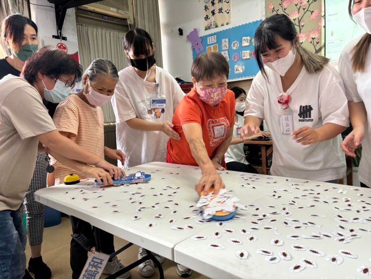 实习生志工带着长辈玩拍蟑螂游戏