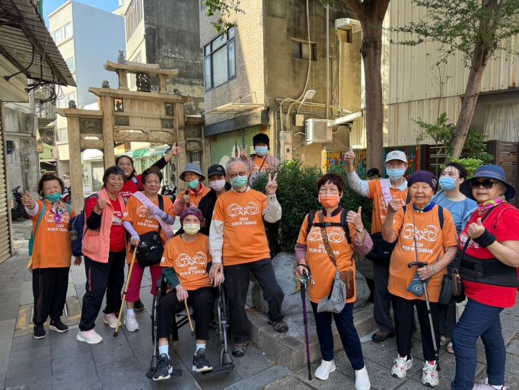 志工与长者驻足新竹市市定古蹟“杨氏节孝坊”