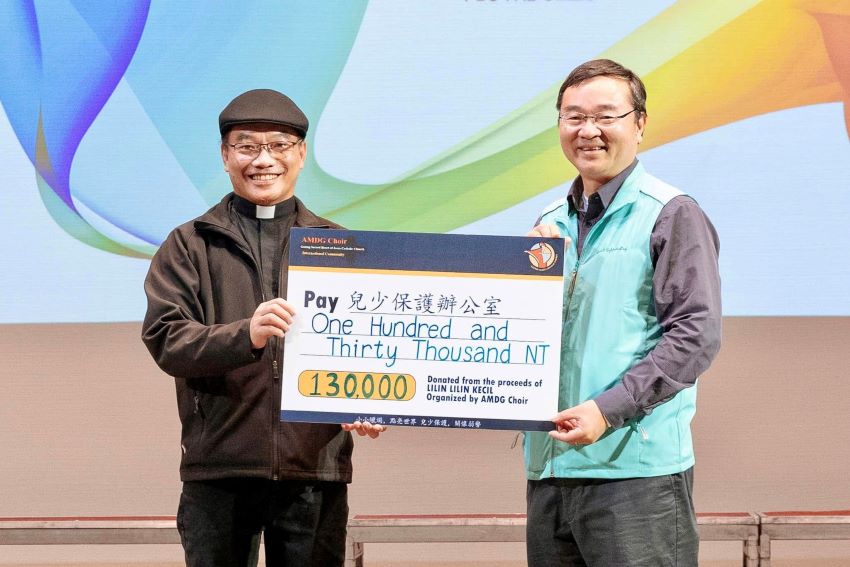 全数捐款由耶稣圣心堂本堂主任裴育圣神父 (左) 代表 AMDG 圣咏团致赠给儿少保护办公室,由主任李骅神父代表接受。