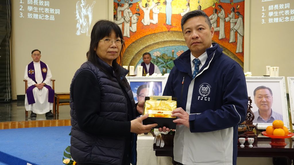 藍校長致贈紀念品給沈鶴璉神父家屬代表頤福園洪主任