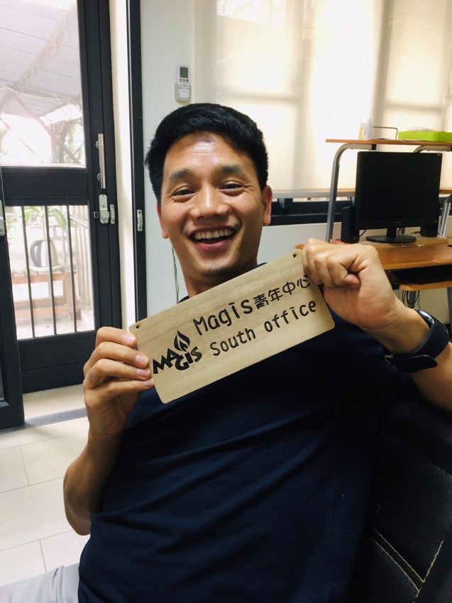 柯家铭修士拿着 Magis 青年中心南部办公室的挂牌