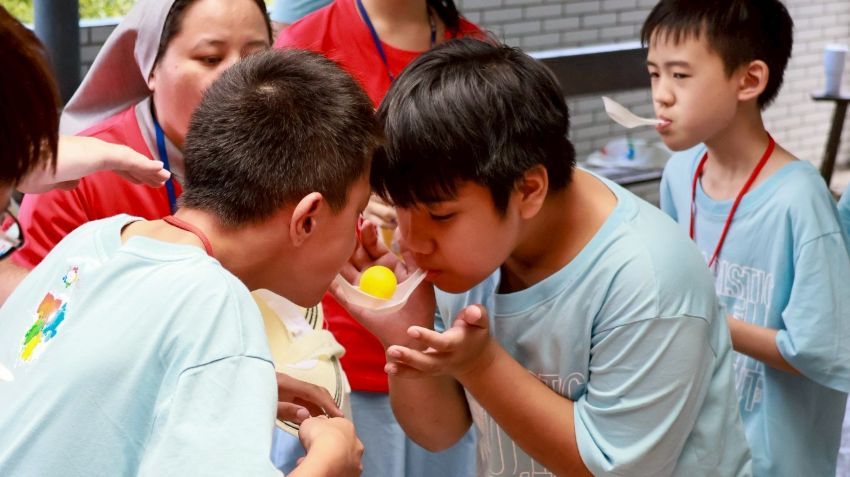 孩子同心协力传乒乓球