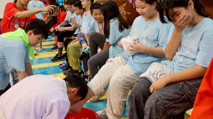 邓立仁神父(画面左下角)为孩子洗脚