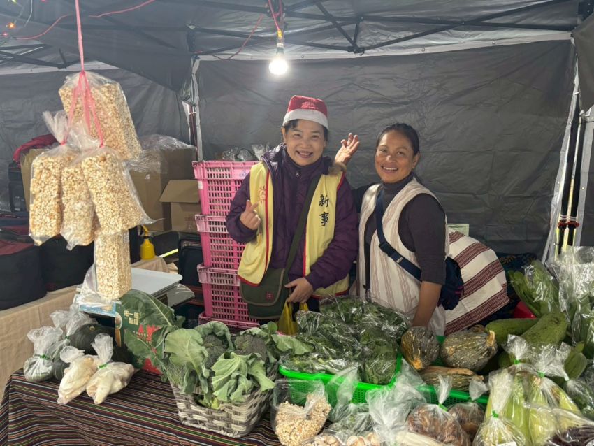 新事中心执行长钟佳伶(左)与原住民伙伴在蔬菜摊位前合影