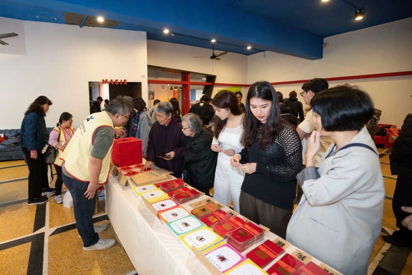 音樂會結束後，眾人欣賞著精美紅包袋還有義賣的文創商品